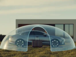 Namas, automobilis ir lagaminas, pritvirtintas po apsauginiu skydu.